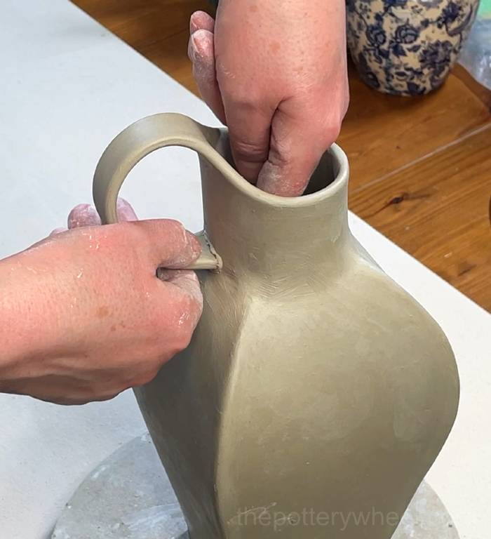 Pressing the handle onto the neck of the petal-shaped vase