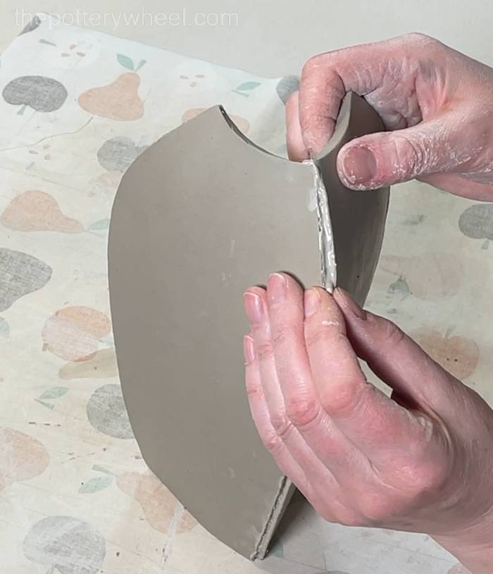 pinching the join of the petal shaped vase together