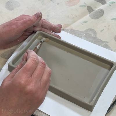 smoothing the clay coil in the corrner