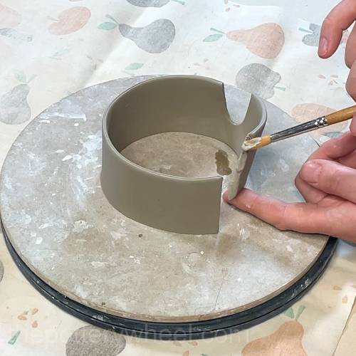 applying clay slip to the scored edge