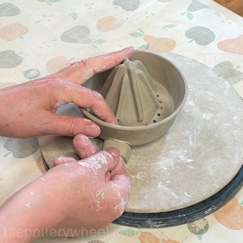pressing the tab on the lemon squeezer